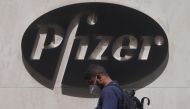 FILE PHOTO: A man walks past a sign outside Pfizer Headquarters in the Manhattan borough of New York City, New York, U.S., July 22, 2020. REUTERS/Carlo Allegri/File Photo