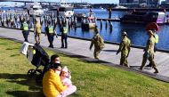 A group of police and soldiers patrol the Docklands area of Melbourne on August 2, 2020, after the announcement of new restrictions to curb the spread of the COVID-19 coronavirus. / AFP / William WES