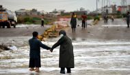 Commuters make their way along a flooded road after a monsoon rain in Pakistan's port city of Karachi on August 8, 2020. / AFP / Rizwan TABASSUM