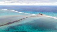 TOPSHOT - This aerial view taken on August 6, 2020 shows a large patch of leaked oil and the vessel MV Wakashio (R), belonging to a Japanese company but Panamanian-flagged, that ran aground near Blue Bay Marine Park off the coast of south-east Mauritius./