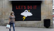 A woman in a protective mask walks during the coronavirus disease (COVID-19) pandemic in Pontevedra, Spain, August 13, 2020. REUTERS/Miguel Vidal