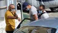 The man with a blue cap who is believed to be Manchester United captain Harry Maguire is escorted by plain-clothes police officers to the police station of the island of Syros, Greece, August 21, 2020. Giorgos Solaris/Intimenews