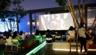 People watch a movie during a screening on a rooftop of a shopping mall on the opening night of the 10th Beijing International Film Festival that has been scaled down and largely moved online due to the outbreak of the coronavirus disease (COVID-19), in B