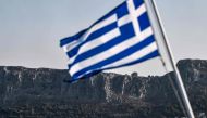 The Hellenic Navy Roussen or Super Vita class Fast Missile Patrol Boat P 71 HS Ritsos patrols off the tiny Greek island of Kastellorizo (Megisti) in front of a Greek flag, in the Dodecanese, the furthest south eastern Greek Island, two kilometers from the