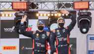 First placed (C) driver Ott Tanak of Estonia and his co-driver Martin Jarveoja of Estonia celebrate on the podium after the Rally Estonia on September 6, 2020 in Tartu, south Estonia. / AFP / RAIGO PAJULA