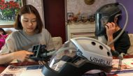 Students Tran Nguyen Khanh An, 14, and Do Trong Minh Duc, 16, work at home with a prototype helmet named Vihelm, which they designed to protect nurses and doctors from contracting the coronavirus disease (COVID-19) at hospitals, in Hanoi, Vietnam Septembe