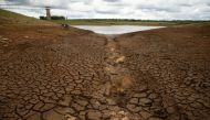 Caked mud is seen before a small patch of water as the region deals with a prolonged drought at a dam near Bulawayo, Zimbabwe, January 18, 2020. Picture taken January 18, 2020. REUTERS/Philimon Bulawayo/File Photo
