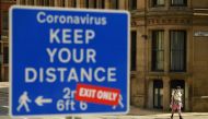 (FILES) In this file photo taken on July 31, 2020 A sign requesting pedestrians to follow the governments social distancing guidelines is on view in the centre of Manchester, northwest England. / AFP / Oli SCARFF