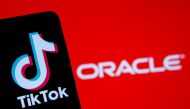 A smartphone with the Tik Tok logo is seen in front of a displayed Oracle logo in this illustration taken, Septemeber 14, 2020. REUTERS/Dado Ruvic/Illustration
