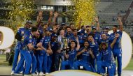 (FILES) In this file photo taken on May 13, 2019, Mumbai Indians team players hold the trophy as they celebrate their victory against Chennai Super Kings after the 2019 Indian Premier League (IPL) Twenty20 final cricket match at the Rajiv Gandhi Internati