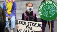 Swedish climate activist Greta Thunberg holds a poster reading 