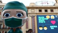 A man wearing a protective face mask poses for a picture next to an oversized model of a health worker amid the outbreak of the coronavirus disease (COVID-19), in Madrid, Spain September 24, 2020. REUTERS/Sergio Perez
