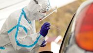 A medical staff member wearing a protective suit takes a swab as people are tested for the coronavirus disease (COVID-19) at a newly opened drive-in sampling station in Prague, Czech Republic, October 7, 2020. REUTERS/David W Cerny

