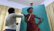 Marcellina Akpojotor creates an art piece of a woman with a face mask using waste Ankara fabric in Lagos, Nigeria August 18, 2020. Picture taken August 18, 2020. REUTERS/Seun Sanni
