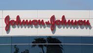 In this file photo taken on August 28, 2019 a sign on a building at the Johnson & Johnson campus shows their logo in Irvine, California. Johnson & Johnson said October 12, 2020, it had temporarily halted its Covid-19 vaccine trial because one of its parti