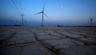 Cracked earth marks a dried-up area near a wind turbine used to generate electricity at a wind farm in Guazhou, 950km (590 miles) northwest of Lanzhou, Gansu Province September 15, 2013. REUTERS/Carlos Barria/File Photo