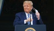 US President Donald Trump takes his mask off before speaking from the South Portico of the White House in Washington, DC during a rally. AFP / MANDEL NGAN
