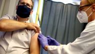 FILE PHOTO: A healthcare worker of the free influenza vaccination programme vaccinates a citizen against the flu inside a tram, as the global spread of the the coronavirus disease (COVID-19) continues, in Vienna, Austria, October 1, 2020. REUTERS/Lisi Nie