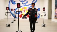 Philip Colbert poses for a photograph with robots that allow viewers to interactively engage with his Lobsteropolis exhibition at a preview event at the Saatchi Gallery in London, Britain, October 28, 2020. Picture taken October 28, 2020. REUTERS/Simon Da