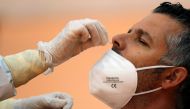 FILE PHOTO: A healthcare worker takes a swab sample from a man to be tested for the coronavirus disease (COVID-19) during a massive test in the small Andalusian village of Arriate, Spain November 7, 2020. REUTERS/Jon Nazca/File Photo
