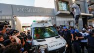 An ambulance carrying Argentine soccer great Diego Maradona leaves the clinic where Maradona underwent brain surgery, in Olivos, on the outskirts of Buenos Aires, Argentina November 11, 2020. REUTERS/Agustin Marcarian
