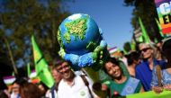 (FILES) In this file photograph taken on September 21, 2019, Europe Ecologie Les Verts (EELV) Green Party deputy and Mayor of Grande-Synthe Damien Careme (C) and Europe Ecologie Les Verts (EELV) European MP Karima (in green with the giant ice cream) march