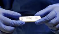 A staff member holds a rapid COVID-19 antigenic test made by Swiss drugmaker Roche, at the smear center of the University Hospital Zurich (USZ), as the spread of the coronavirus disease (COVID-19) continues, in Zurich, Switzerland November 19, 2020. Reute