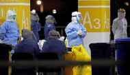 This photo taken on November 22, 2020 shows health workers in protective suits waiting to conduct COVID-19 coronavirus tests on staff at Pudong Airport in Shanghai. China OUT
/ AFP / CNS / STR