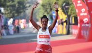 Ethiopian athlete Yalemzerf Yehualaw celebrates after crossing the finish line to win the women's 2020 Airtel Delhi half marathon in New Delhi on November 29, 2020. / AFP / Sajjad HUSSAIN