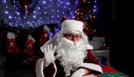Janos Nemes, dressed as Santa Claus, waves as he interacts with children by video in a photo studio, amid the coronavirus disease (COVID-19) outbreak, in Budapest, Hungary, December 1, 2020. Picture taken December 1, 2020. REUTERS/Bernadett Szabo