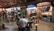 People have their lunch at the Maxwell market hawker centre in Singapore on December 17, 2020, a day after Singapore's street food culture was included on a United Nations Educational, Scientific and Cultural Organization (UNESCO) list of intangible cultu