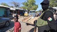 A Nigerien police officer stands in the road near the Diffa airport in South-East Niger, near the Nigerian border, on December 23, 2020.  AFP / Issouf SANOGO
