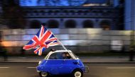 A man waves Union flags from a BMW Isetta in central London. (AFP / DANIEL LEAL-OLIVAS)