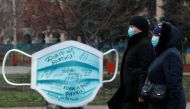 Women walk past an installation showing a protective face mask amid the coronavirus disease (COVID-19) outbreak in Kyiv, Ukraine December 28, 2020. REUTERS/Valentyn Ogirenko
