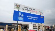 FILE PHOTO: Containers and other goods are sold beneath a coronavirus disease (COVID-19) awareness billboard at a marketplace in Harare, Zimbabwe, November 26, 2020. REUTERS/Philimon Bulawayo