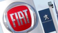 FILE PHOTO: The logos of car manufacturers Fiat and Peugeot are seen in front of dealerships of the companies in Saint-Nazaire, France, November 8, 2019. REUTERS/Stephane Mahe