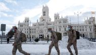 Members of the military walk past the City Hall building after heavy snowfall in Madrid, Spain January 10, 2021. Reuters/Susana Vera