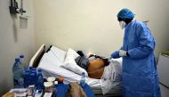 Professor Moussa Seydi, wearing his personal protective equipment (PPE) talks to a patient, who is suffering from coronavirus disease at the infectious diseases department of the University Hospital Fann, in Dakar, Senegal January 7, 2021. Reuters/ Zohra 