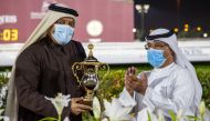 QREC Racing Manager Abdulla Rashid Al Kubaisi presenting the Muaither Cup to the winning team's representative. 