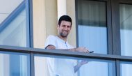 Tennis star Novak Djokovic stands on his balcony at the accommodation where he is quarantining in advance of the Australian Open to be played in Melbourne, in North Adelaide, Australia, January 19, 2021. AAP Image/Morgan Sette 