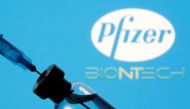 A vial and syringe are seen in front of a displayed Pfizer and Biontech logo in this illustration taken January 11, 2021. REUTERS/Dado Ruvic/Illustration

