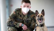 A member of a military poses with Filou, the 3-year-old Belgian shepherd which is able to detect COVID-19 in humans' saliva samples, in Hanover, Germany, February 3, 2021. REUTERS/Hannibal Hanschke