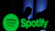 A trader is reflected in a computer screen displaying the Spotify brand before the company begins selling as a direct listing on the floor of the New York Stock Exchange in New York, U.S., April 3, 2018. REUTERS/Lucas Jackson/File Photo