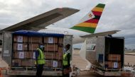 FILE PHOTO: Workers offload boxes as Zimbabwe's first batch of coronavirus disease (COVID-19) vaccines arrives from China, in Harare, Zimbabwe, February 15,2021. REUTERS/Philimon Bulawayo/File Photo
