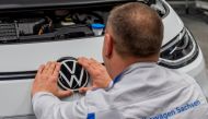 An employee fixes a VW sign at a production line of the electric Volkswagen model ID.3 in Zwickau, Germany, February 25, 2020. REUTERS/Matthias Rietschel/File Photo