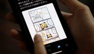 Japanese manga artist Kamentotsu shows his his four-panel strip comic 'Koguma's Cake Shop' on his smartphone at his workspace in Tokyo, Japan October 8, 2020. Picture taken October 8, 2020. REUTERS/Issei Kato