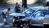 FILE PHOTO: Los Angeles County Sheriff's Deputies inspect the vehicle of golfer Tiger Woods, who was rushed to hospital after suffering multiple injuries, after it was involved in a single-vehicle accident in Los Angeles, California, U.S. February 23, 202