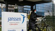 A woman leaves with her bike at Johnson and Johnson's subsidiary Janssen Vaccines in Leiden, Netherlands March 9, 2021. REUTERS/Piroschka van de Wouw/File Photo