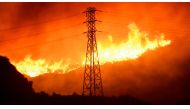 A wind-driven wildfire burns near power line tower in Sylmar, California, U.S., October 10, 2019. REUTERS/Gene Blevins/File Photo
