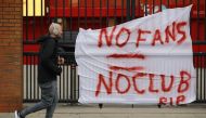 A man runs past anti Super League banners outside Anfield as twelve of Europe's top football clubs launch a breakaway REUTERS/Phil Noble
